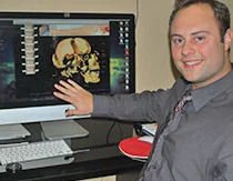 Man pointing at skull scan image on computer monitor at Back On Track Cranial Center